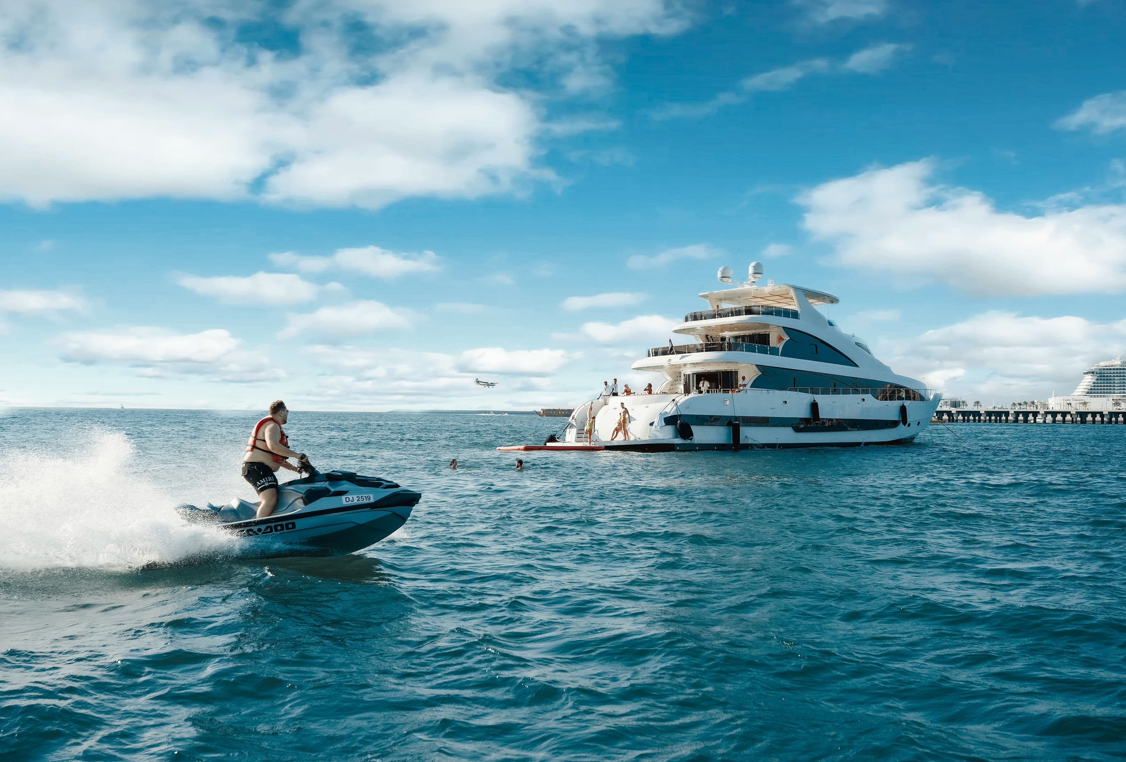 A motor yacht moored beside a stately waterfront estate